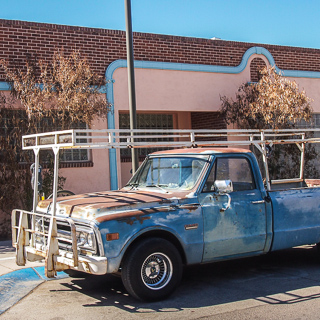 rusty car in same colors as building, downtown tucson