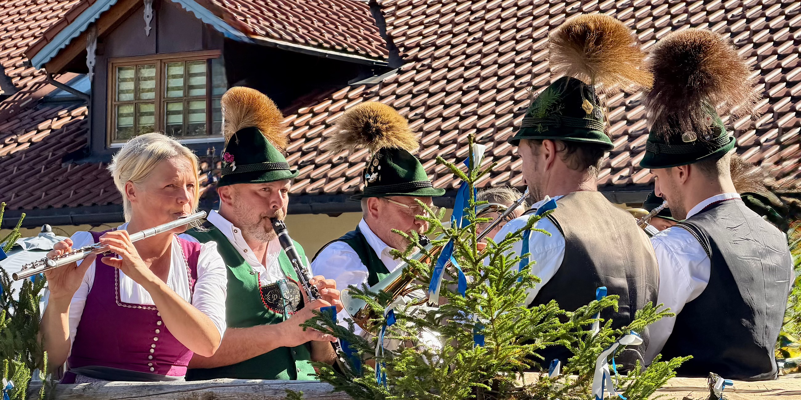 Muzikanten in tracht op een paardenwagen tijdens de Michaeliritt