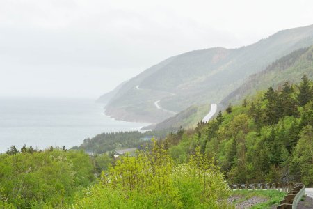 De Cabot Trail hangt zo her en der aan het steile klif 