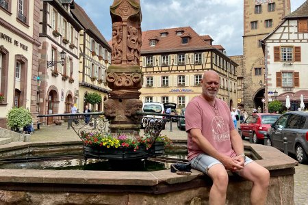 Pat poseert bij een fontein in Ribeauvillé