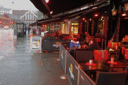 Het is erg regenachtig, toch zitten mensen op een terras, raaaar!